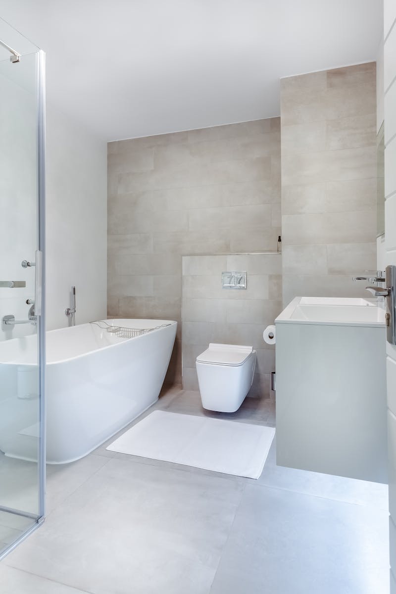 Elegant minimalistic bathroom featuring bathtub and sleek fixtures.
