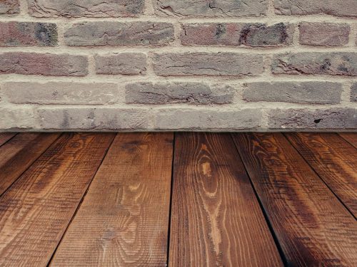 Stylish vintage brick wall background complemented by a rustic wooden floor.